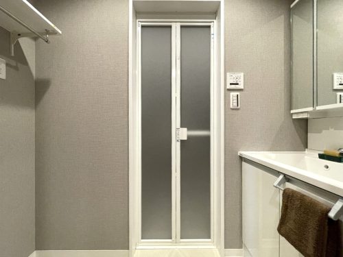 洗面室にはオープン収納と三面鏡のある洗面台